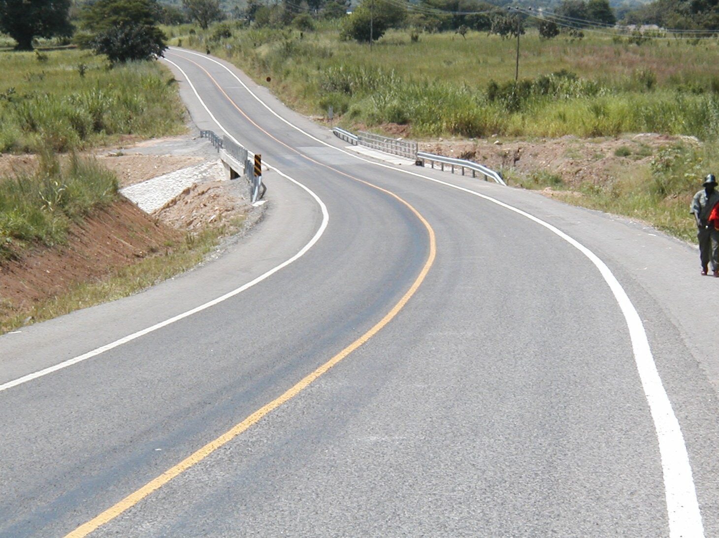 Prismo® Crystalex hot applied thermoplastic applied as white and yellow line marking on curved road in Uganda.