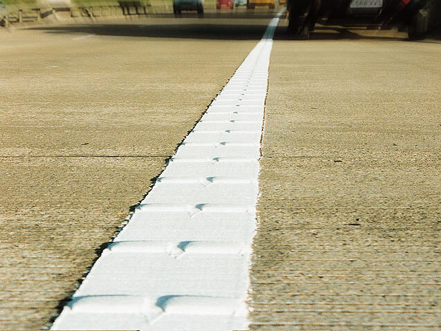 Close-up image of Prismo® Vibraline® hot applied thermoplastic applied on road surface as profiled white line marking.