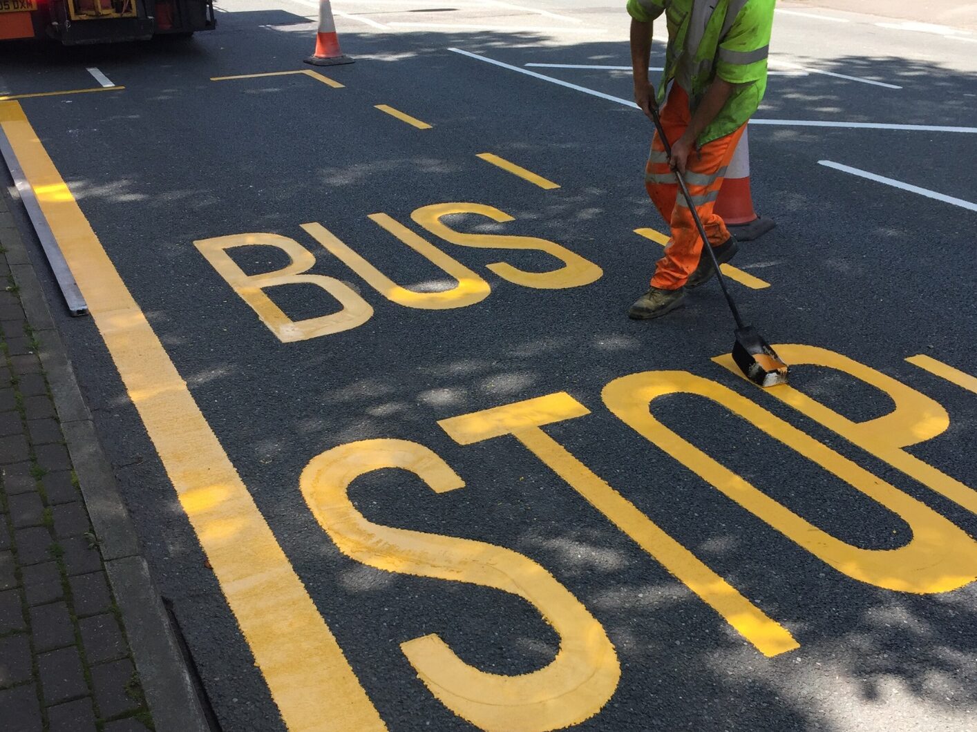 Prismo Guidemaster hot applied thermoplastic road marking used for yellow line and 'bus stop' written on bus lane road surface