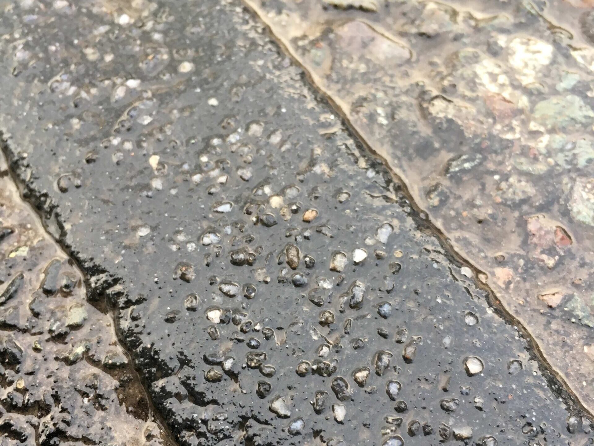 Close-up of Prismo PFT Overbanding preformed thermoplastic road marking strip showing surface texture and embedded aggregate