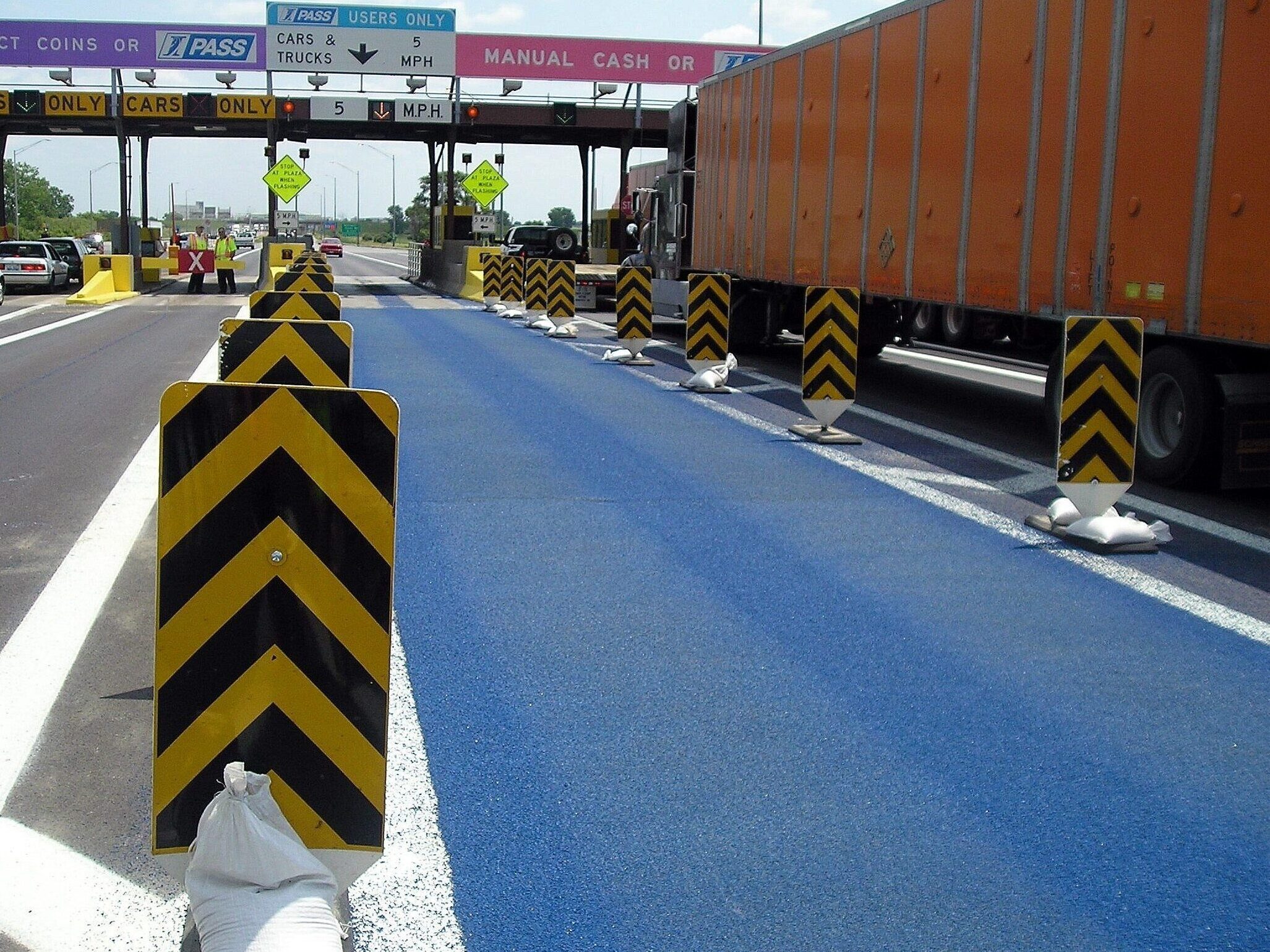 High friction surfacing Prismo Tyregrip in blue applied at a toll booth in Illinois to improve vehicle safety and lane guidance.