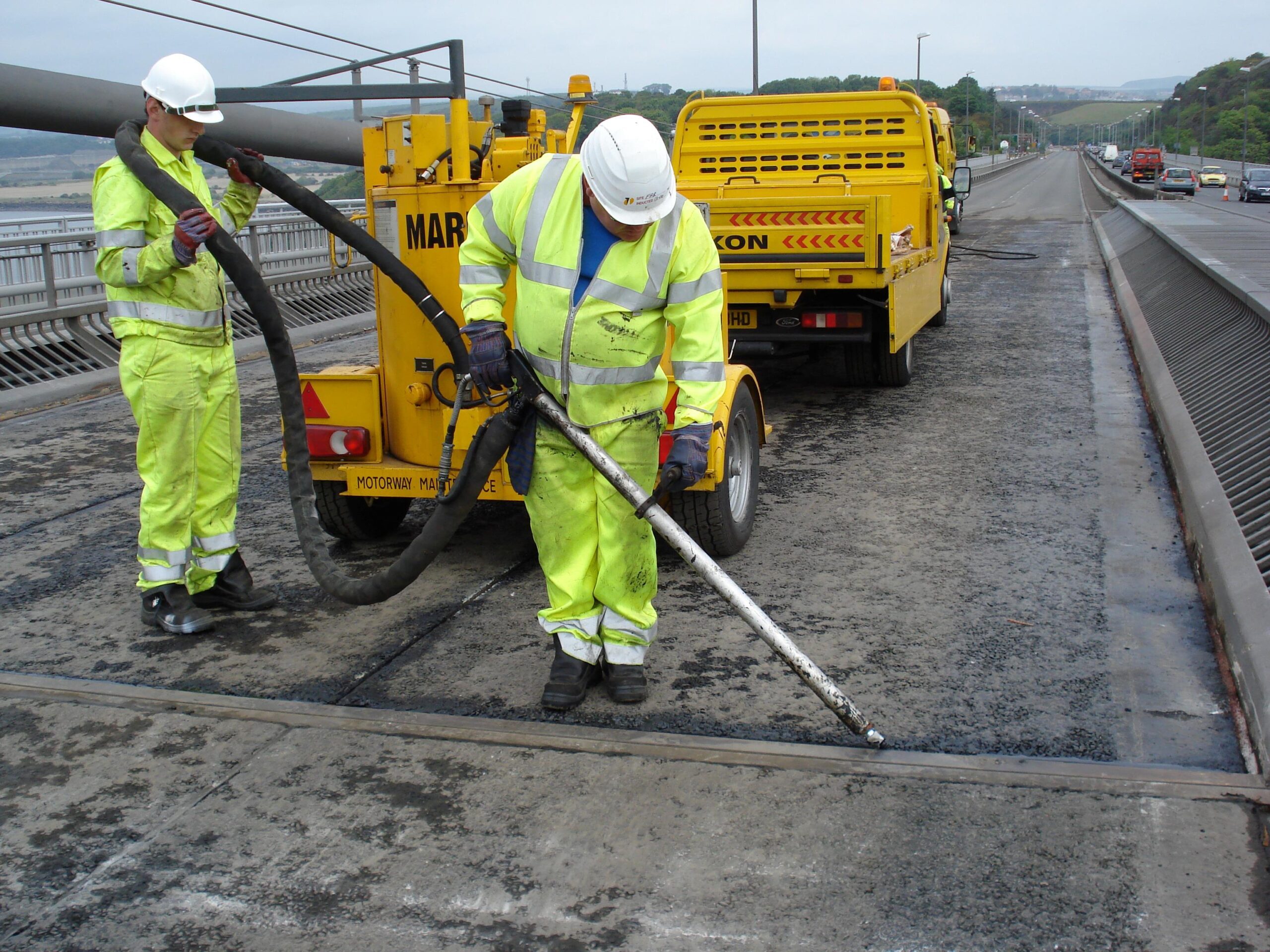 Multiseal 40 skid resistant joint and crack sealant applied on bridge deck using Prismo bituminous road repair product.