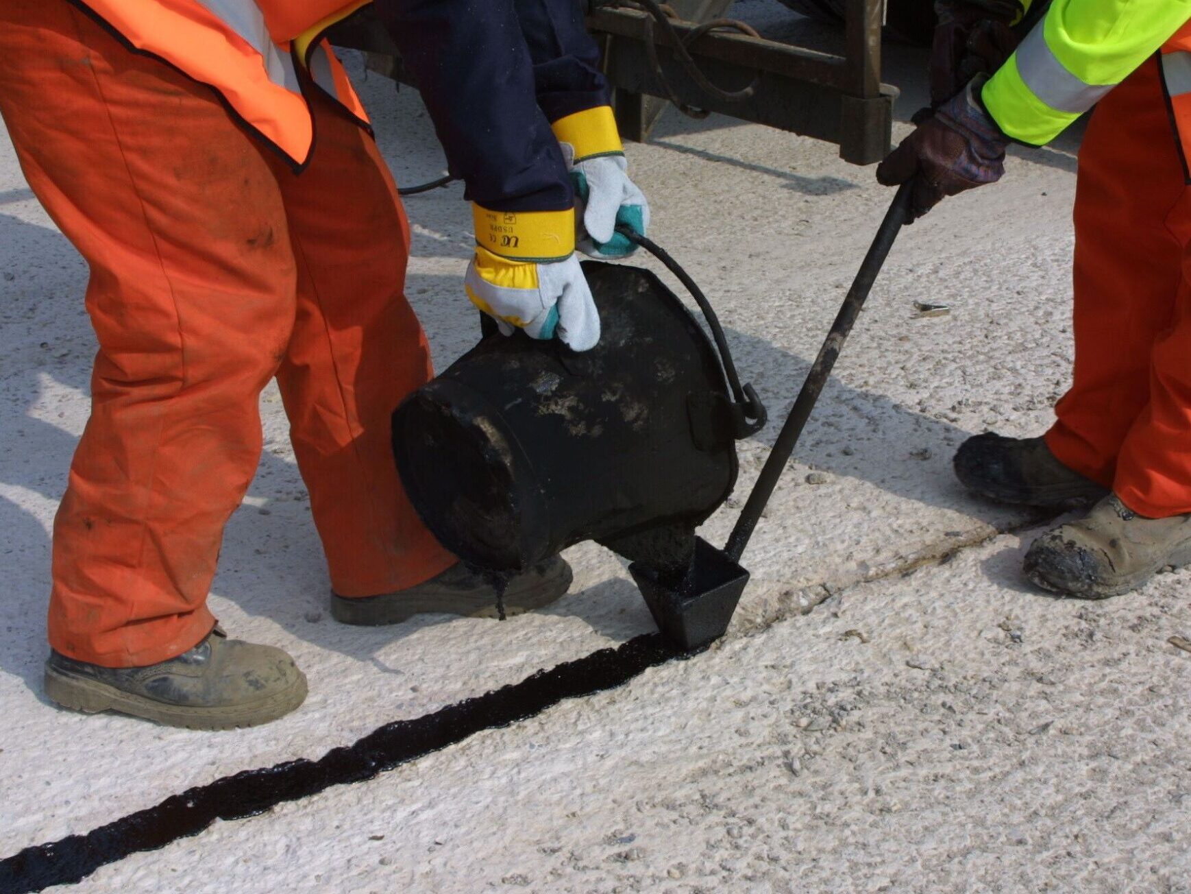 Hand application of Prismoseal durable joint and crack sealant on concrete pavement using hot-pour method