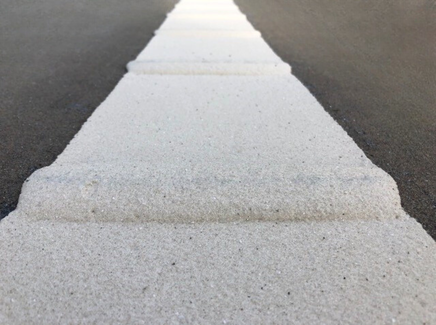 Close-up of Prismo® Vibraline hot applied thermoplastic applied on road surface as profiled white line.