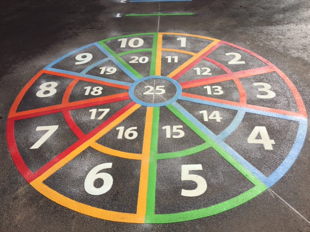 Colourful circular number game with numbers 1 to 25 made from Prismo preformed thermoplastic on a playground surface.