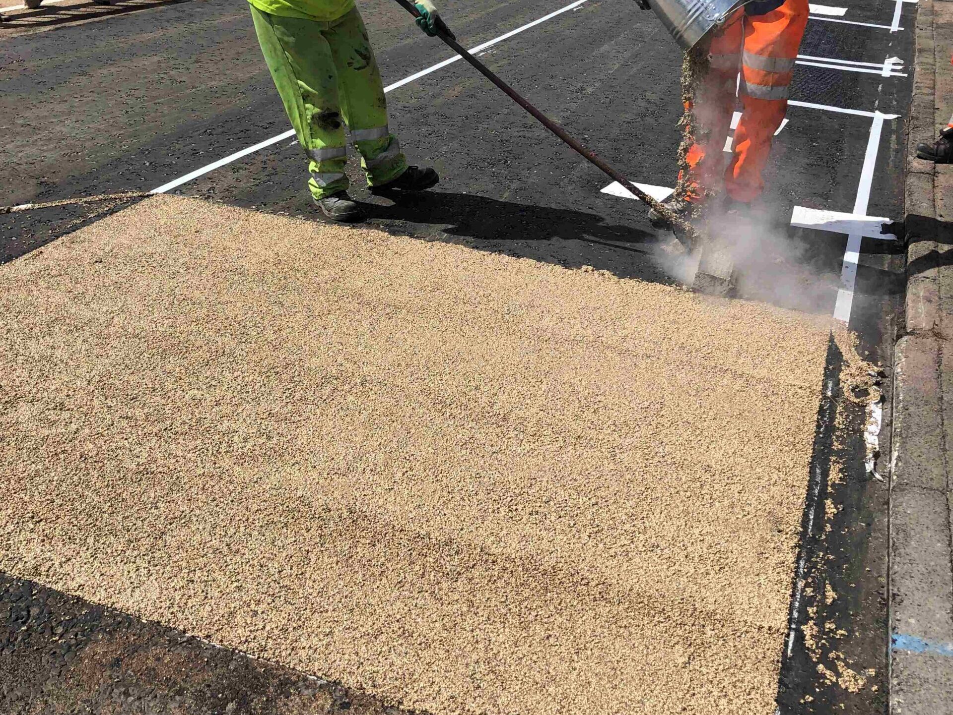 Buff Zebraflex high friction surfacing being applied by a contractor on a road in Bury
