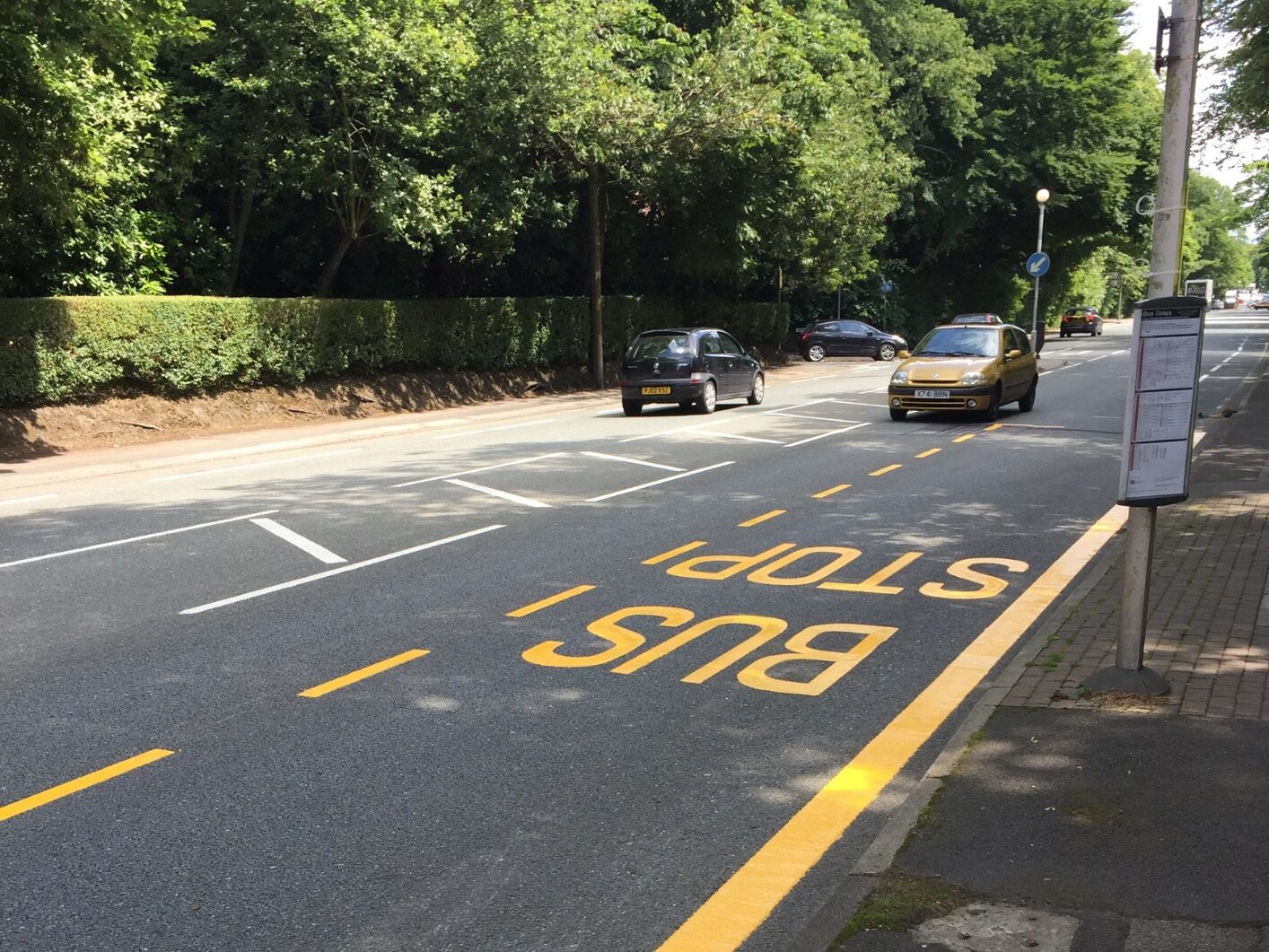 Prismo® Guidemaster yellow line marking and 'bus stop' written on road surface, outside bus stop in Bolton.