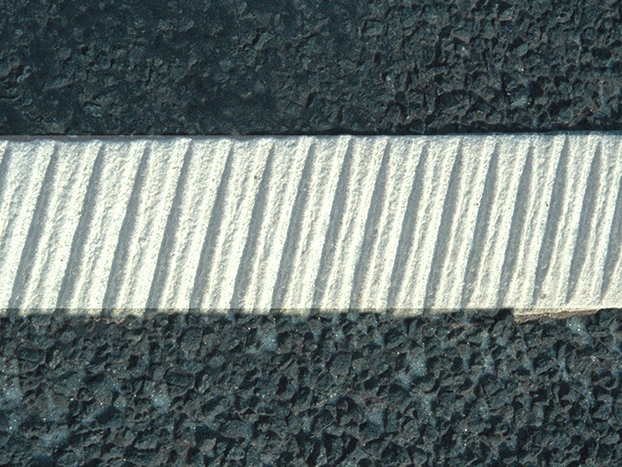 Close-up of Prismo® Rainline® hot applied thermoplastic applied as a profiled white line on the road surface.