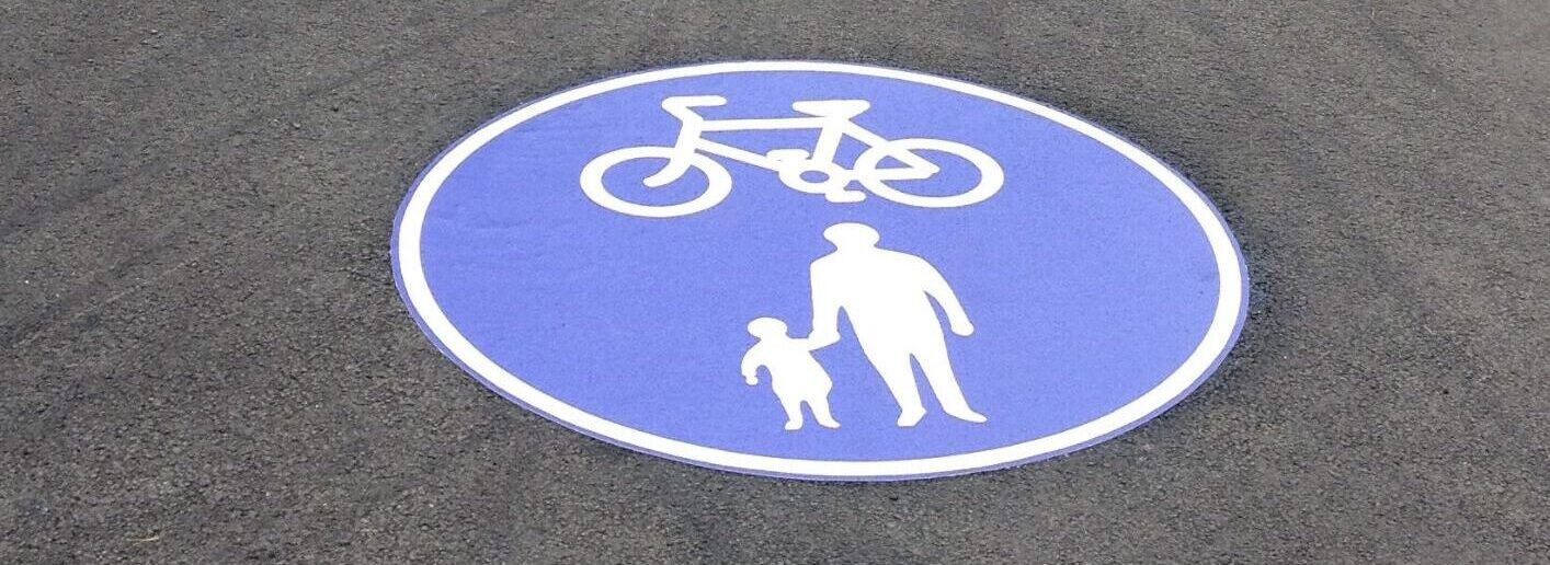 Prismo® Preformed Thermoplastic circular blue and white pre cut symbol including parent, child and cycling design on asphalt.