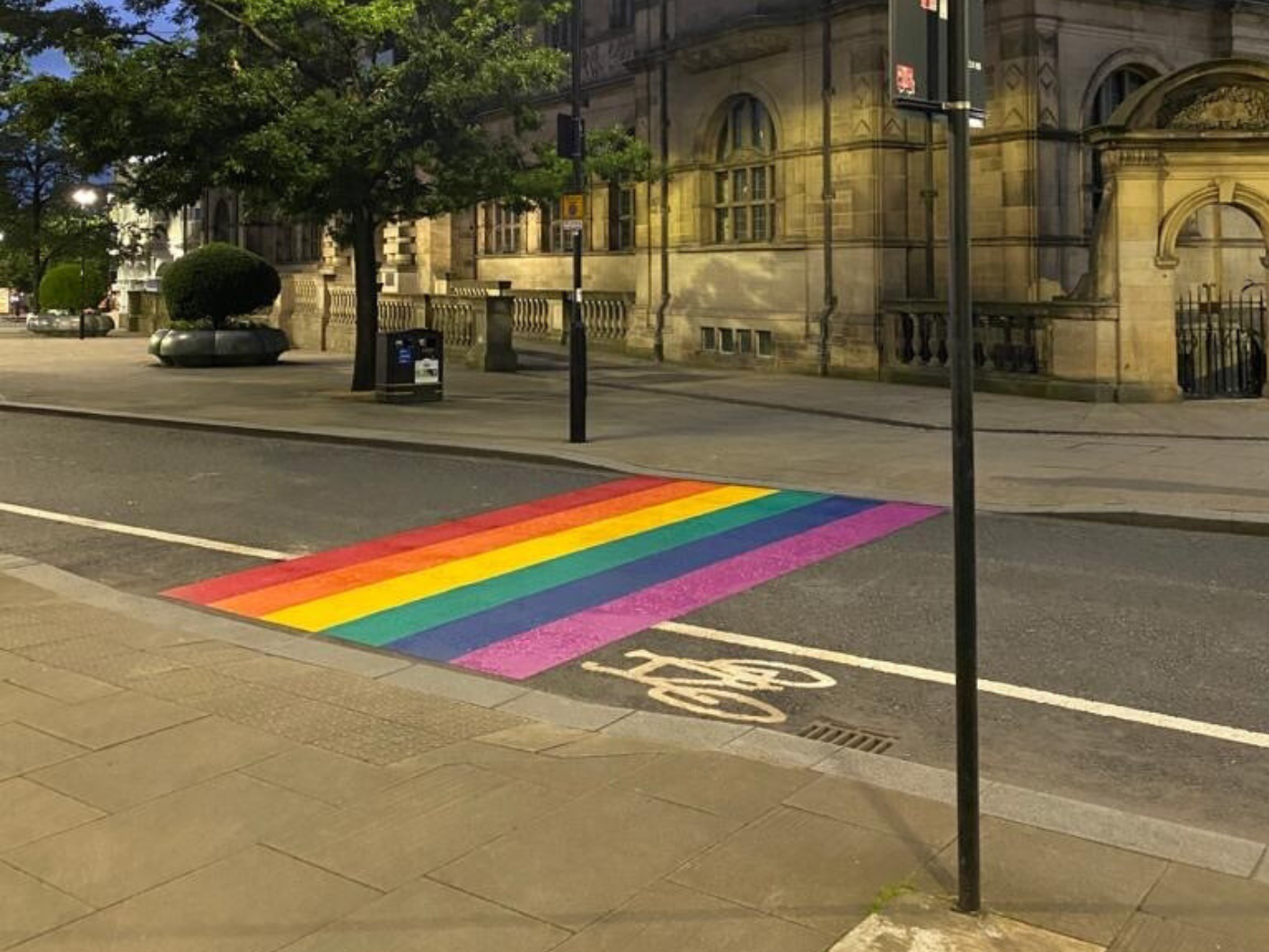 Rainbow street crossing made from Prismo preformed thermoplastic road markings in Sheffield, photographed at night.