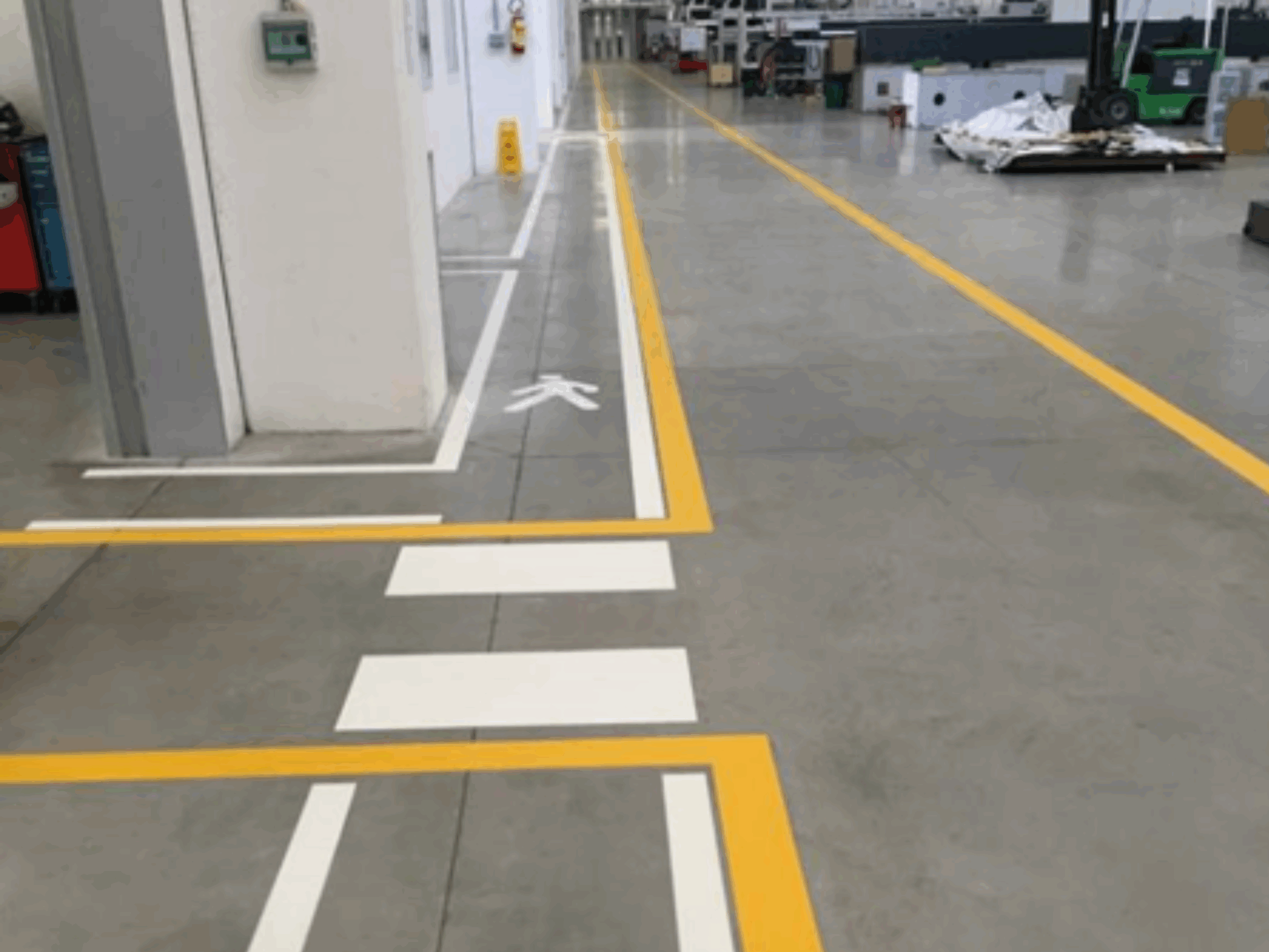 Prismo Vernisol Epoline indoor flooring in white and yellow on a factory walkway