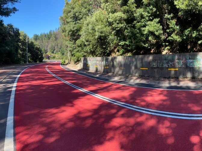 Red Prismo Tyregrip high friction surfacing applied on a bend of a main road in Chile under sunny daylight