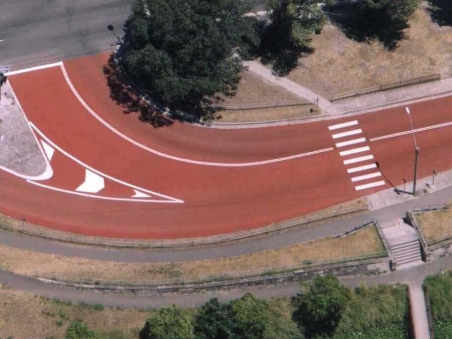 Red Prismo Tyregrip high friction surfacing applied to a red bus lane at a main road junction